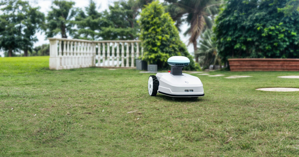 Robotic mower operating in a residential backyard with house and garden