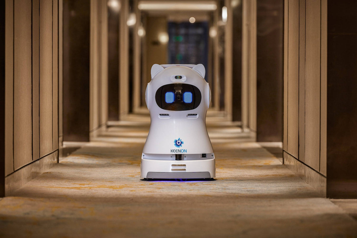Kleenbot C30 cleaning robot in a hotel hallway, efficiently sweeping, vacuuming, and mopping floors with its advanced cleaning technology.