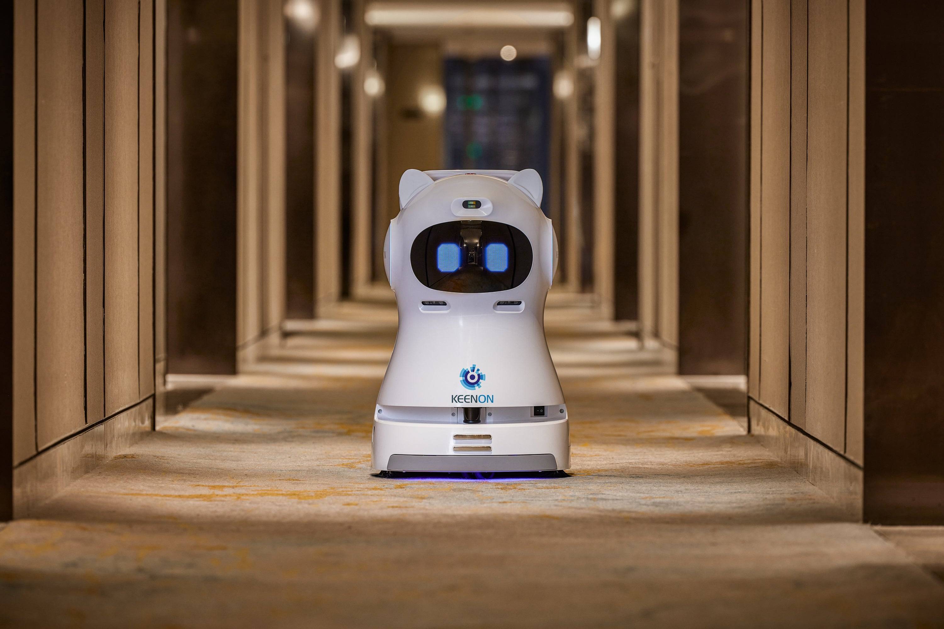 Kleenbot C30 cleaning robot in a hotel hallway, efficiently sweeping, vacuuming, and mopping floors with its advanced cleaning technology.