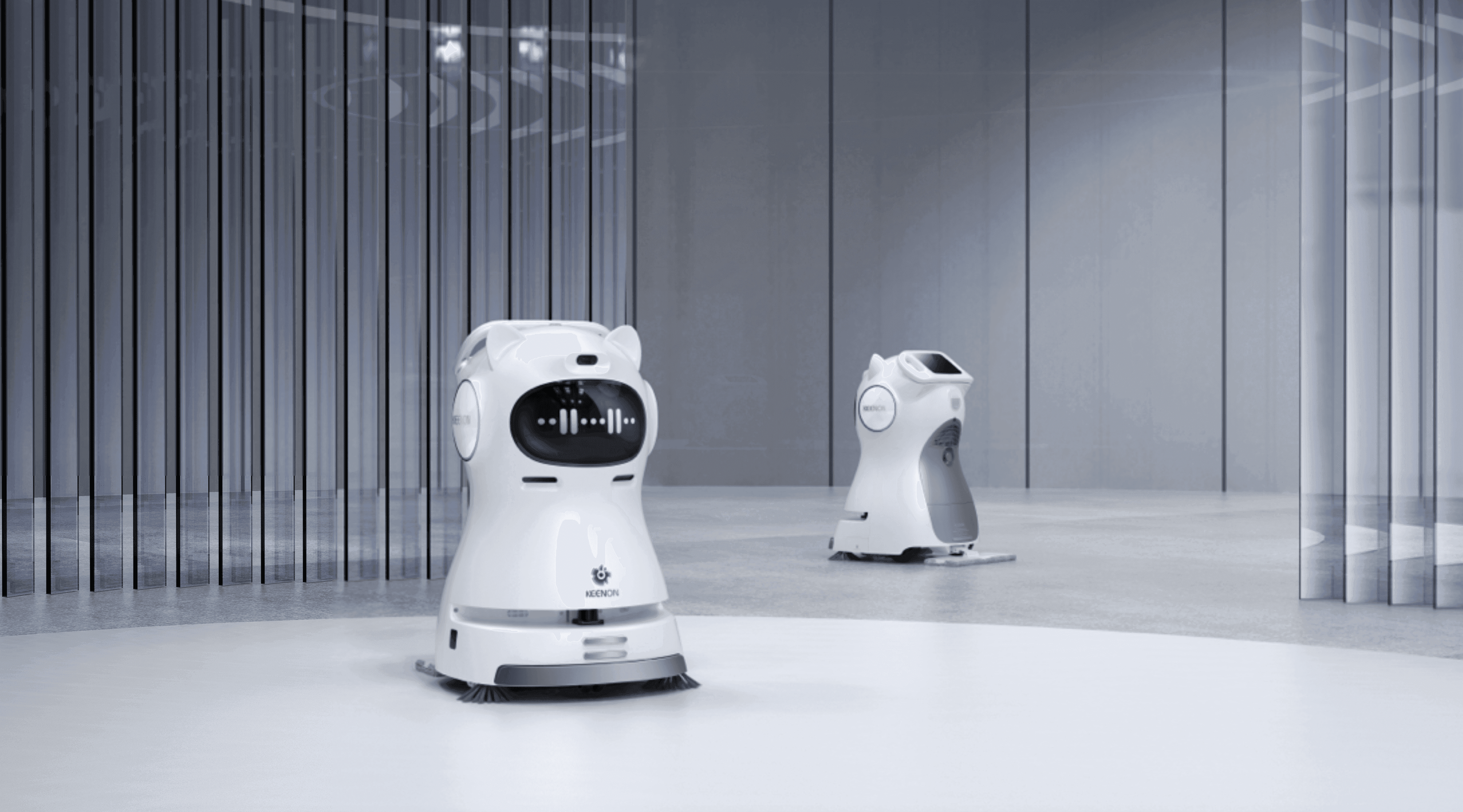 Two Kleenbot C30 cleaning robots operating in a modern commercial space, demonstrating their autonomous cleaning and smart navigation features.