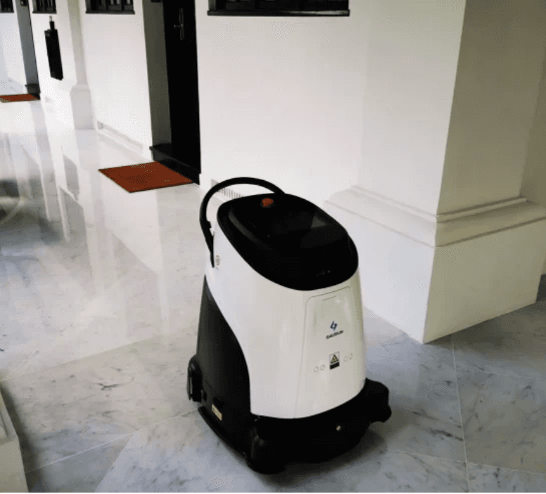 Gausium Vacuum 40 AI commercial cleaning robot autonomously cleaning a marble hallway in a commercial building or hotel.