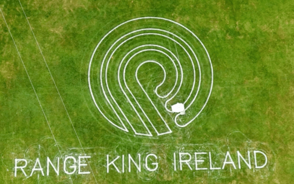 Aerial view of a sports field with a robot lawn mower trimming the grass