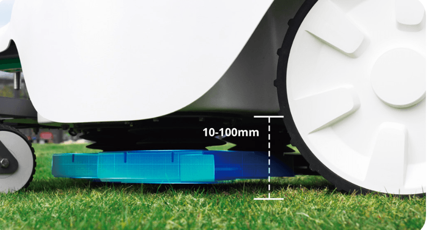 Close-up of autonomous mower cutting grass with height adjustment indicator