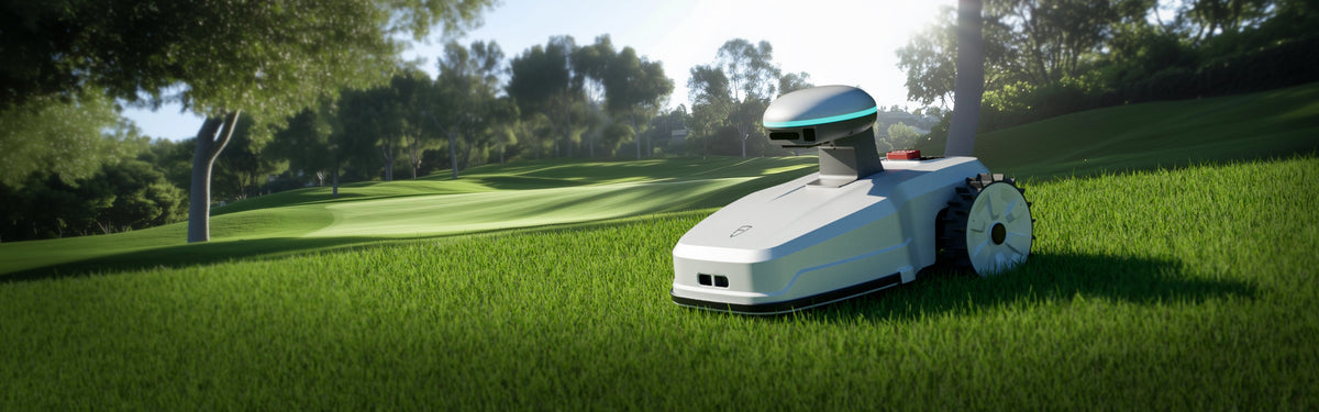 Robotic lawn mower on green grass with trees in background